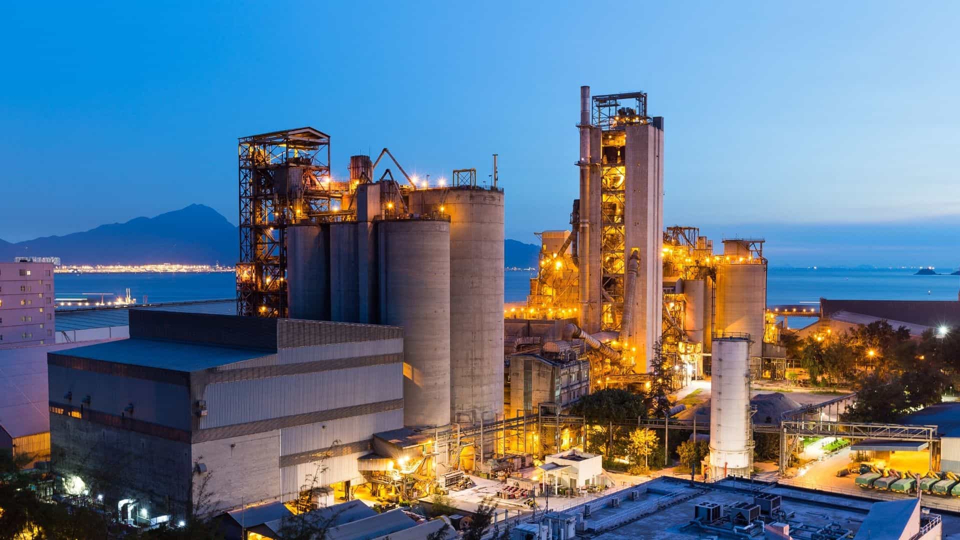 Modern industrial manufacturing facility at dusk, representing product carbon footprint measurement and governed emissions data